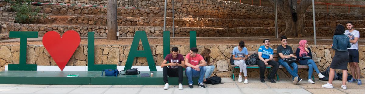 Students chatting next to a sign that reads “I love LAU.”